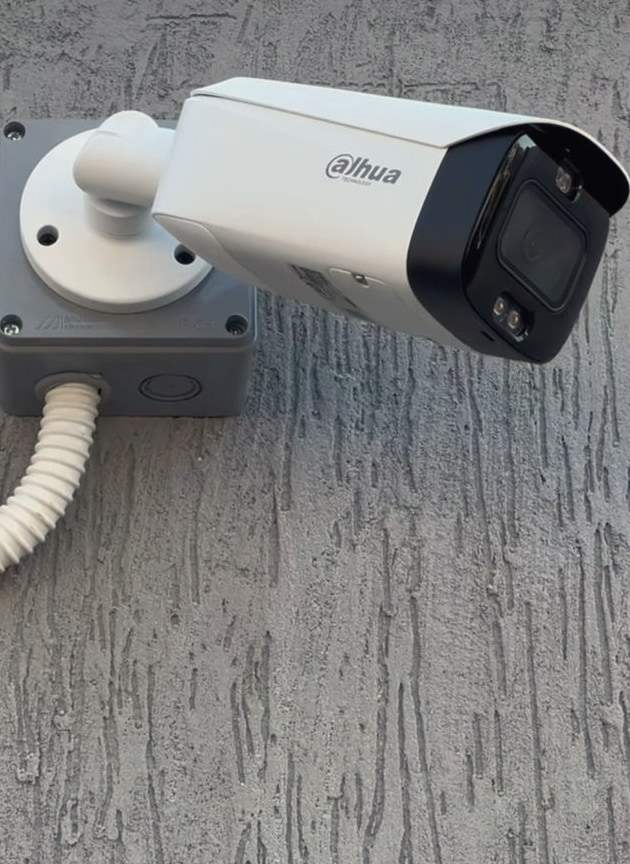 A Dahua bullet camera mounted on a textured wall