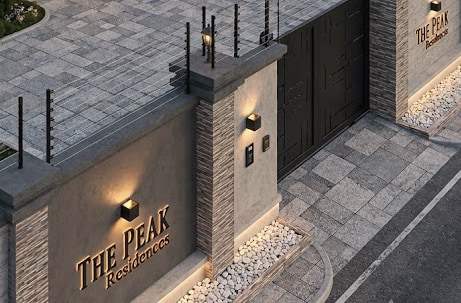 The entrance wall of The Peak Residence, with electric fence wires along the top